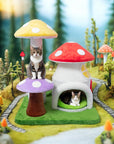 In a forest setting, one cat sits on the purple mushroom of the Magic Mushroom Cat Tree while another lies in the condo