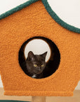 Detail of a black cat inside the house of the Brown Wood House Cat Tree