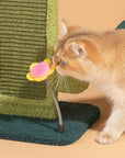 A cat playing with the flower-shaped toy on top of the Cactus Cat Scratcher.