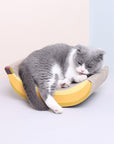 A cat lying comfortably on the Banana Shaped Cat Scratching Pad.