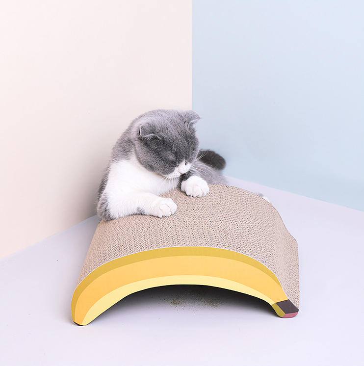 A cat scratching the back side of the Banana Shaped Cat Scratching Pad.