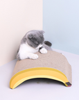 A cat scratching the back side of the Banana Shaped Cat Scratching Pad.