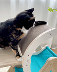 A chubby cat scratching the corrugated board of the Moon Ship Cat Tree